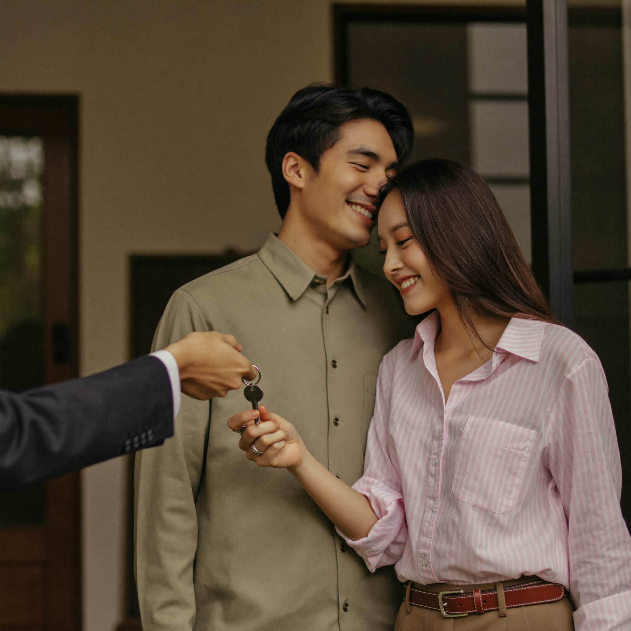 Agen menyerahkan kunci rumah kepada pasangan pembeli
